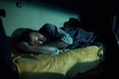 © Drazen - Tired truck driver sleeping on cabin's bed at night.