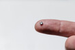 Close up of electronic microchip on human finger.