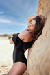 Attraktive Frau posiert im Badeanzug am Sandstrand am See