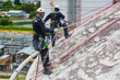 © chitsanupong - Male two worker inspection wearing safety first harness rope safety line working at a high place on tank roof spherical