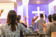 Singing together, raising hands to worship Jesus in the church