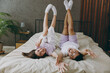© ViDi Studio - Full length back rear view young couple two family man woman she he in t-shirt pajama lying in bed raise up leg look camera rest spend time together in bedroom home in room hotel Real estate concept