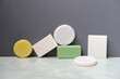 © Tatonka - various colored and shapes body bar soaps on green bathroom tile against gray wall, every day cleansing and washing