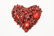 heart shaped pink vegan muesli with berries isolated on white background