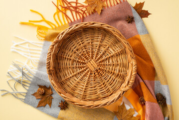 Wall Mural - Autumn mood concept. Top view photo of empty wicker basket anise yellow maple leaves pine cones and plaid on isolated pastel beige background