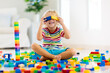 © famveldman - Child playing with toy blocks. Toys for kids.