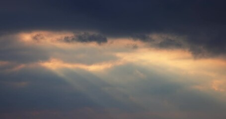 Wall Mural - sunbeams shining through moving dramatic white clouds. dramatic cloudy blue sky and warm sunrise or 