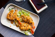 Fried prawns in batter served with sesame and sauce on fresh lettuce salad, asian cuisine