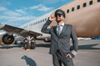 © Friends Stock - Cheerful aircraft pilot standing outdoors at airport