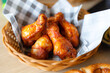 barbecue spicy chicken wings close up on wooden basket shot with selective focus