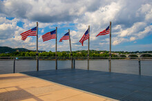 American Flags Flying On The Edge Of The Pier Surrounded By The Flowing Waters Of The Tennessee River And Lush Green Trees With Blue Sky And Powerful Clouds At Ross's Landing In Chattanooga Tennessee 