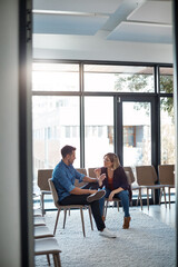 Wall Mural - Serious, professional business woman talking to work colleague in modern startup office. Manager having casual conversation with male employee. Coworkers meeting and discussing plans for a project