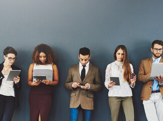 Poster - Group or team of business people working and browsing with wireless technology in studio against a grey background. Digital marketing colleagues networking online to advertise a startup company