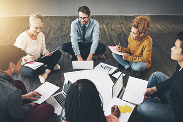 Aufkleber - Group of business people talking, planning with documents and sitting in a meeting on floor in an office together at work. Diverse, happy and smiling casual workers writing notes and browsing on tech