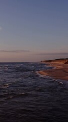 Wall Mural - Panoramic view of a deserted beach washed by sea waves