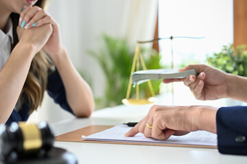 Wall Mural - Female lawyer or business legal consultant receives a bribe. cropped shot