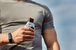 © Aleksandr - Muscular athlete rests after a workout, an athlete eats a protein bar. A young athlete eats an energy bar while enjoying chocolate after a hard workout at the stadium
