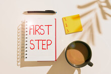 Text Sign Showing First Step. Conceptual Photo Pertaining To The Start Of A Certain Process Or Beginning Notebook With Important Messages On Desk With Coffee, Notes And Pen.