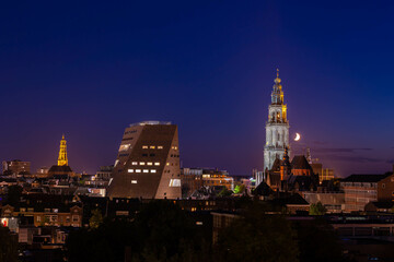 Overview of cityscape with architecture features traditional houses and church at night, A city in the northern of Netherlands, The capital city and main municipality of Groningen province in Holland.