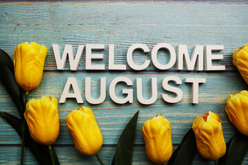 Canvas Print - Welcome August alphabet with yellow tulip flower on wooden background