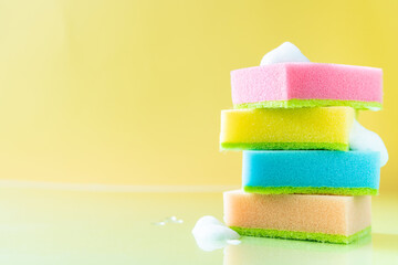 Cleaning concept - colorful dishwashing sponges on bright background