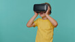 © Andrii Iemelianenko - Little toddler children boy using headset helmet app to play simulation game. Watching virtual reality 3D 360 video film. Young preschool kid in VR goggles isolated alone on blue studio background