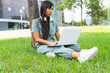 © ADDICTIVE STOCK - Female student using laptop near tree