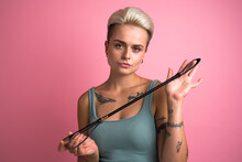 Confident bdsm woman posing with black whip and enjoying dominance at relationships