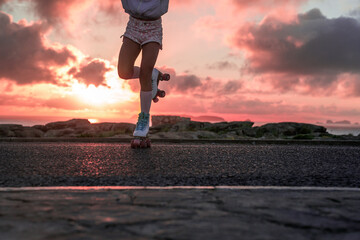 Tanned teenager standing at the roller boots at asphalt highway road after riding