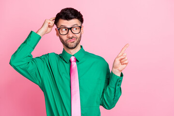 Sticker - Photo of doubtful unsure man dressed green shirt eyewear finger head pointing empty space isolated pink color background