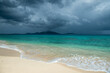 Jost Van Dyke surrounded by tropical squall clouds viewed across turquoise Caribbean waters from Apple Bay Beach on Tortola, BVI 