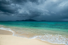 Jost Van Dyke Surrounded By Tropical Squall Clouds Viewed Across Turquoise Caribbean Waters From Apple Bay Beach On Tortola, BVI 