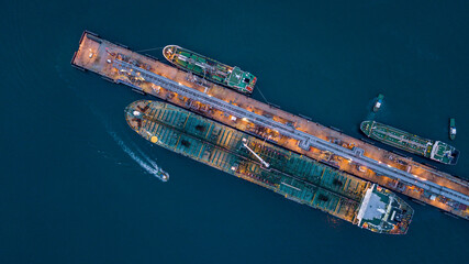 Canvas Print - Aerial view tanker ship vessel unloading at port at night, Global business logistic import export oil and gas petrochemical with tanker ship transportation oil from dock refinery.