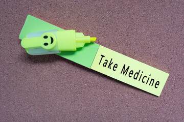 Wall Mural - Take medicine words on yellow note on wooden board.