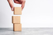 hand holding and stacking wooden block cube step of business growth success. concept of grow success.                