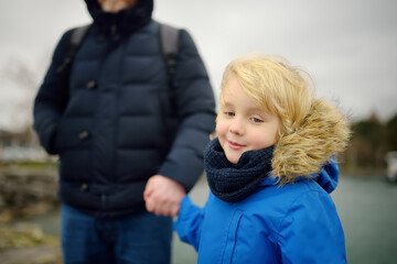 Wall Mural - Father and his son walking on cold windy winter day. Single parent.