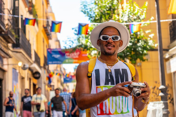 a gay black man at the pride party with a camera, lgbt flag