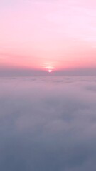 aerial vertical shot of clouds with pink sunset on top
