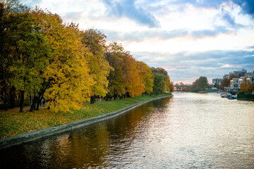 Wall Mural - autumn landscape with yellow trees over the river in sunny weather, reflection of a tree in the rive