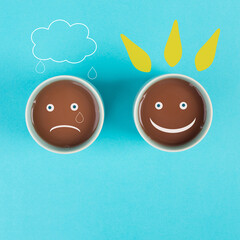 Wall Mural - Cup of coffee with a sad and a happy face, positive and negative mindset, support and evaluation concept
