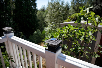 Solar powered lights on outdoor deck post with trees in background