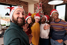 Multiethnic Group Of People Taking Pictures With Tree, Celebrating Festive Season With Christmas Holiday Decorations In Business Office. Colleagues Taking Photos With Seasonal Xmas Ornaments.