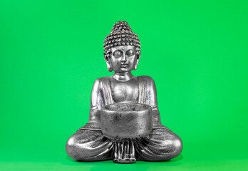 buddha statue with lit candle. green screen