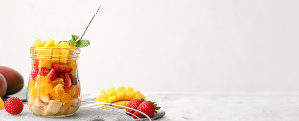 Jar of sweet fruit salad on light table