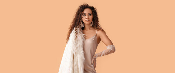 Elegant young African-American woman in evening dress and stylish gloves on beige background