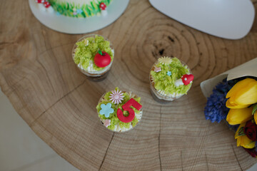 Wall Mural - Baking cakes and cupcakes decorated in forest style, grass, mushrooms and a little princess