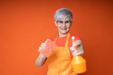 Wall Mural - cheerful elderly woman in apron with cleaning products for cleaning