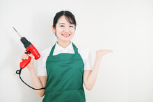 DIYするエプロン姿の日本人女性（ホームセンター）
