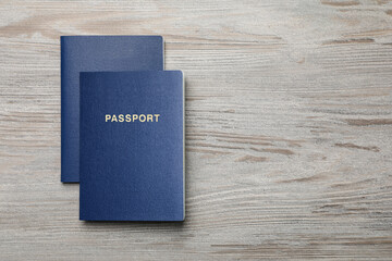 Wall Mural - Blank blue passports on wooden table, flat lay with space for text