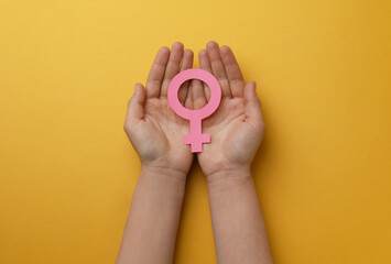 Wall Mural - Woman holding female gender sign on orange background, top view